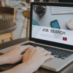 Person typing on a laptop in search for a online job database.