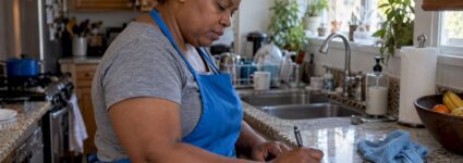 Domestic worker recording hours in a home